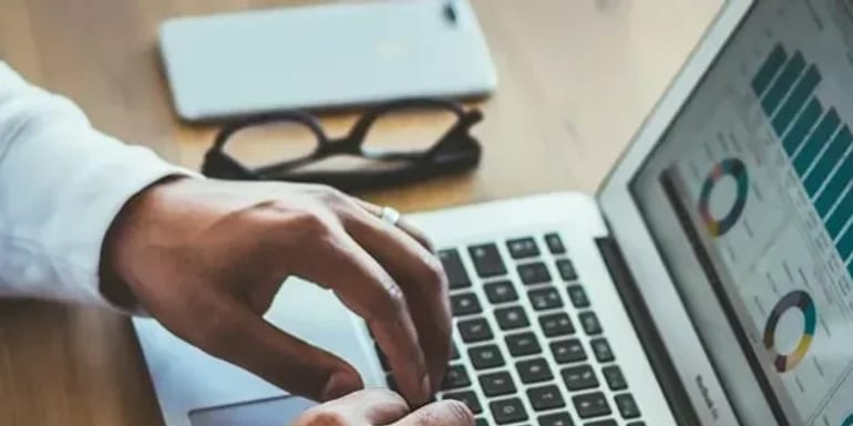 Analista financeira acompanhando o fluxo de caixa no computador